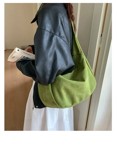 Detail of moss green suede tote bag with soft texture and stylish half-moon design
