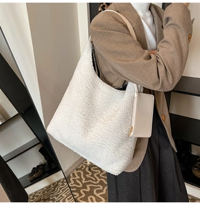 Detail view of white faux fur tote bag with mini leather pouch and shoulder strap on model