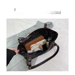 Vista interna della grande borsa tote marrone con tasca zip e spazio per oggetti quotidiani