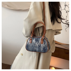 Close-up of sparkling sequin denim crossbody bag with brown leather straps and metal hardware