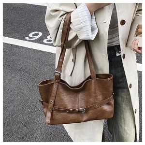 Dettaglio borsa tote vintage marrone scuro con occhielli metallici e trama martellata