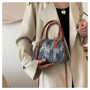 Detail of blue denim shoulder bag with silver sequins and brown leather straps