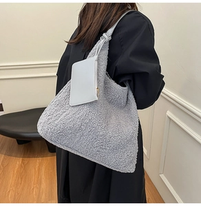 Detail of grey faux shearling tote bag with leather pouch and knot handle detail