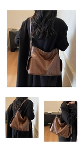 Detailed view of brown vintage large tote bag with side pockets on a professional model