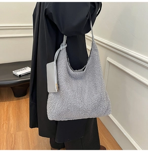 Detail of the fuzzy grey sherpa hobo bag featuring plush texture and leather zip pouch