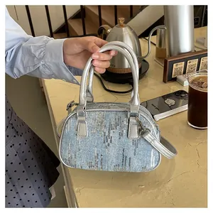 Detail of light blue denim Boston bag with silver sequins and adjustable shoulder strap