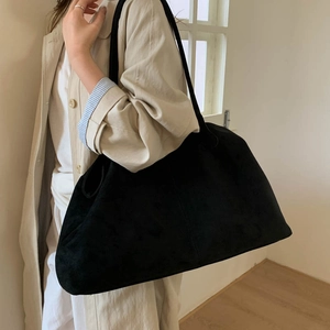 Macro detail of large black suede tote bag showing soft matte texture and draping style