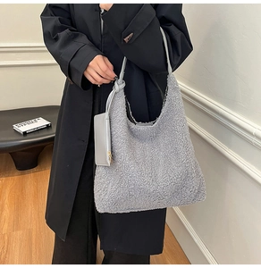 Detail of grey faux fur tote bag showing soft plush texture and matching leather pouch