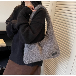Sac à épaule gris en peluche porté par un mannequin montrant sa forme et texture