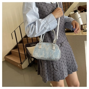 Detail of light blue sequined handbag with silver stripes and adjustable strap for women