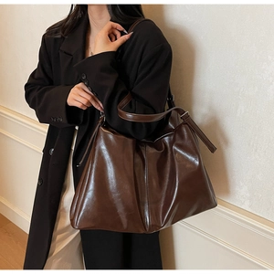 Chic brown oil wax leather tote bag shown on shoulder for daily office commuting outfit