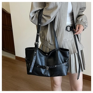 Dettaglio della borsa tote nera vintage con occhielli punk e fibbie argentate