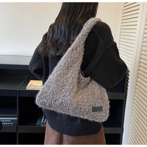 Détail de la texture pelucheuse grise et étiquette en cuir sur ce grand sac hobo