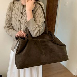 Brown faux suede tote bag shown on shoulder, highlighting large capacity and soft texture