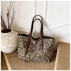 Detailed shot of large leopard print canvas tote bag with premium brown leather handles