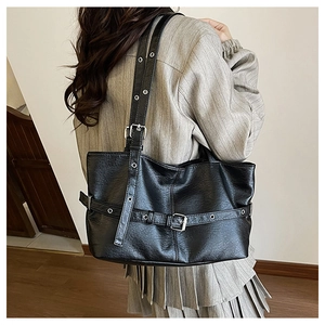 Dettaglio della borsa tote in pelle PU nera con occhielli metallici e fibbie stile punk