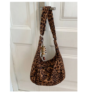 Detail of leopard print hobo bag with wide shoulder strap and boho wooden bead charms