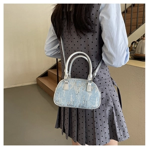 Detailed view of blue sequin handbag with silver handle on a model in lifestyle setting