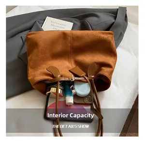 Détail de la capacité interne du sac cabas en daim marron avec tablette et cosmétiques