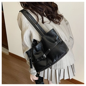 Vista macro dettagliata della borsa tote in ecopelle nera con fibbie metalliche lucide