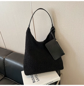 Detail view of black faux fur hobo tote with leather strap and matching small zipper pouch