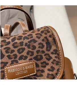 Détail du sac à dos léopard avec garniture en cuir marron et étiquette de mode