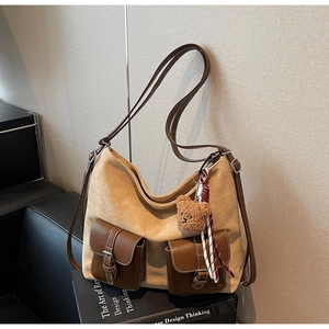Close-up of retro canvas tote bag with brown leather pockets and plush bear charm