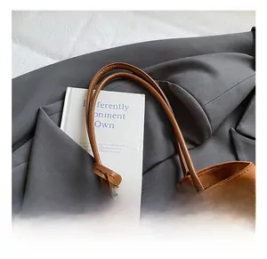 Détails des poignées d'un cabas en daim marron sur un blazer pour un style bureau