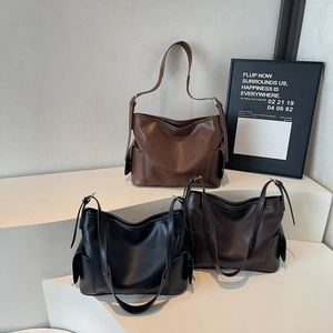 Three vintage leather tote bags in brown, black, and dark coffee on a minimalist background