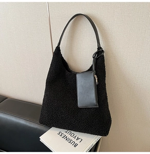 Detail of black faux fur hobo bag with smooth leather strap and small zip pouch