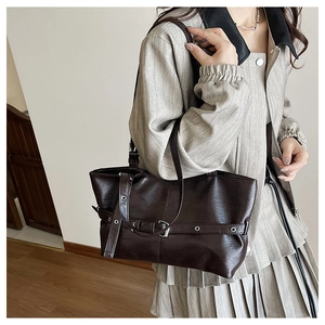 Dettaglio della borsa tote marrone scuro con fibbia vintage e occhielli in metallo