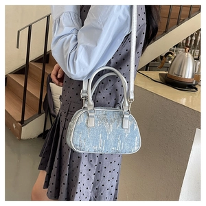 Close-up of light blue sequined mini Boston bag with silver handles in lifestyle setting