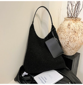 Close-up of black fuzzy faux fur tote bag with matching leather pouch on side