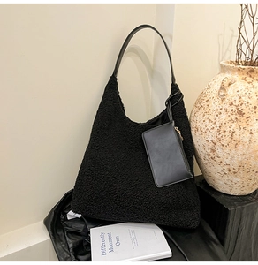 Detail of plush black faux fur hobo bag with leather strap and mini pouch attachment