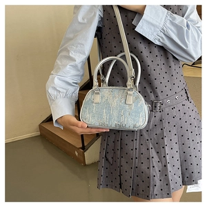 Detailed macro view of denim blue sequins and silver leather handles on a mini handbag
