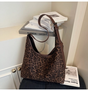 Detail der Leopardenmuster-Tasche mit verstellbarem braunem Lederriemen und Metallschnalle