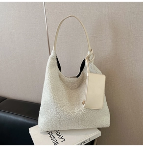 Detail of creamy white fuzzy hobo bag with plush texture and leather shoulder strap