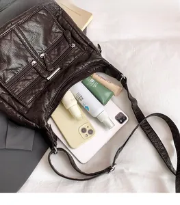 Deep brown tote bag with multiple zipper pockets showing large storage capacity