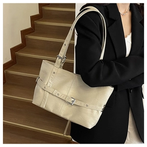 Dettaglio della borsa tote bianco crema con fibbie argentate e texture in ecopelle venata