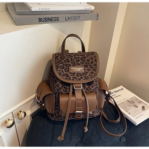 Gros plan du sac à dos léopard avec détails en cuir marron et poches latérales