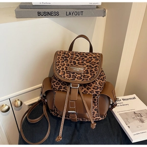 Détail du sac à dos léopard montrant le rabat en cuir avec étiquette et cordon de serrage