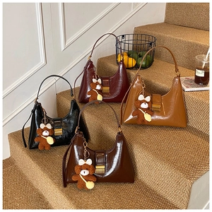 Détail de sacs hobo en cuir brillant en quatre couleurs avec breloques d'ours en peluche