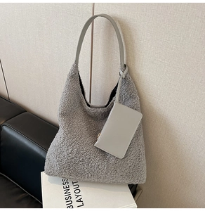 Detail of grey fuzzy shearling tote bag with matching leather coin purse and long strap