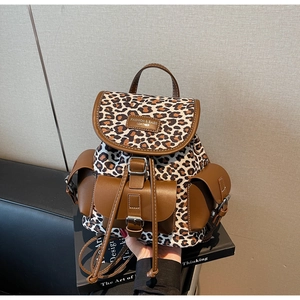 Détail du sac à dos léopard avec garniture en cuir brun et sangles à boucle métal