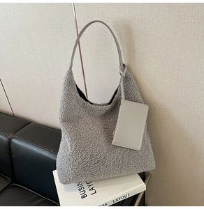 Close-up of grey faux fur tote bag with smooth leather handles and matching pouch