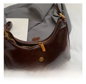 Détail du sac en cuir ciré marron foncé avec fermeture éclair dorée KOSK et finitions métalliques