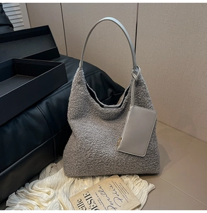 Detail of grey faux shearling hobo bag with matching leather strap and mini pouch