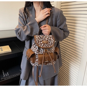 Détail de la toile léopard et du rabat en cuir marron sur un mini sac à dos vintage