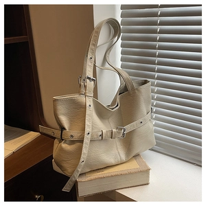 Dettaglio ravvicinato della borsa tote bianco crema con fibbie regolabili e occhielli