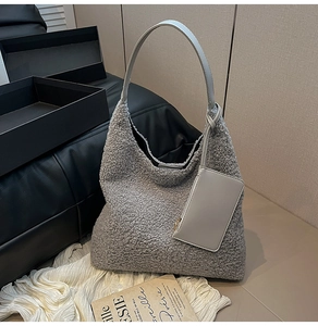 Detail of grey fuzzy fleece hobo bag with a matching small square zipper pouch hanging